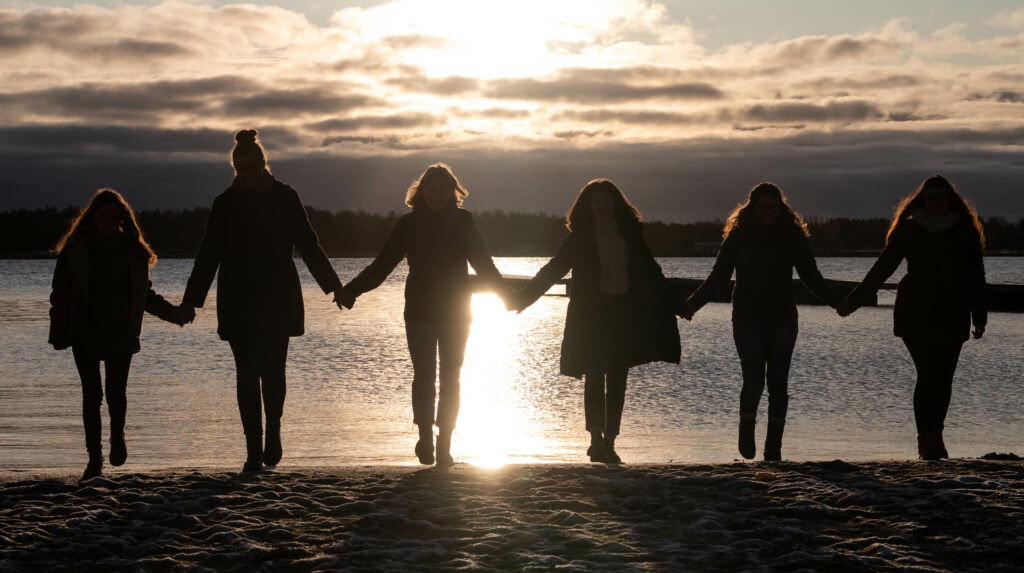 Nuoret auringonlaskussa rannalla